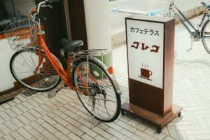 Orange bicycle parked next to cafe sign