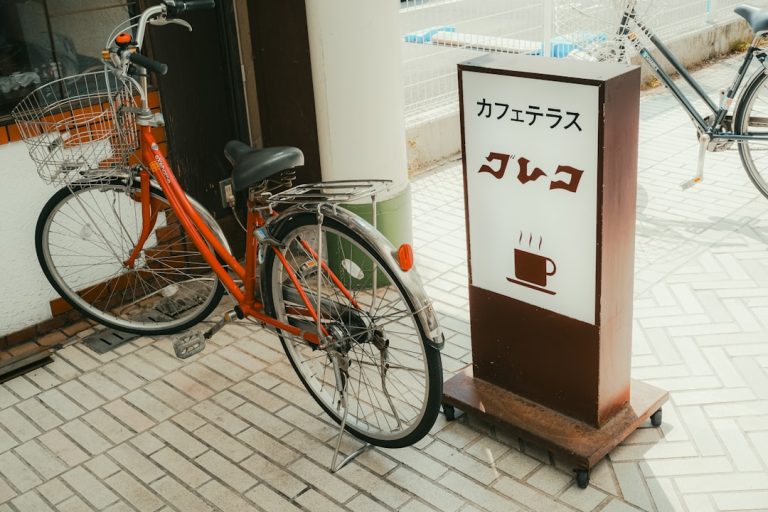 Orange bicycle parked next to cafe sign