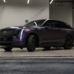 A purple cadillac suv parked in a garage.