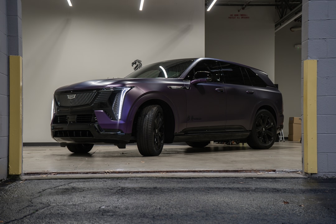 A purple cadillac suv parked in a garage.